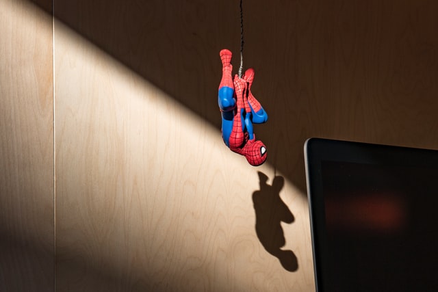Spiderman zwisający nad komputerem